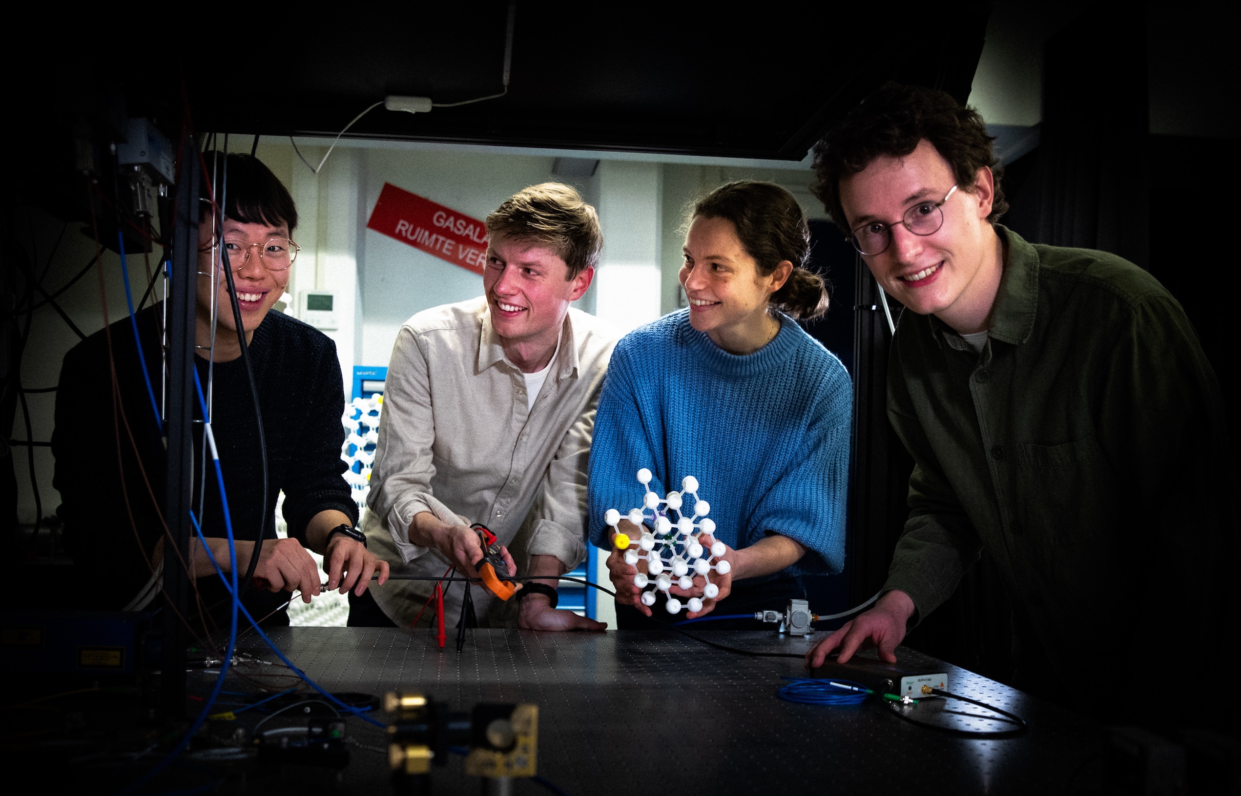 Team picture showing the researchers Jiwon Yun, Kai-Niklas Schymik, Margriet van Riggelen, and Hans Bartling in their optical lab. Picture taken for their paper 'Universal high-fidelity quantum gates for spin qubits in diamond' in Physical Review Applied.
